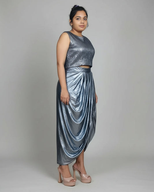Woman in a metallic silver outfit standing indoors with decorative wall items.