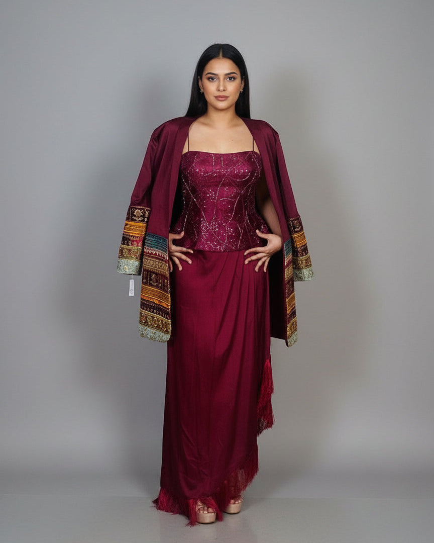 Woman wearing a burgundy dress with a matching jacket against a gray background