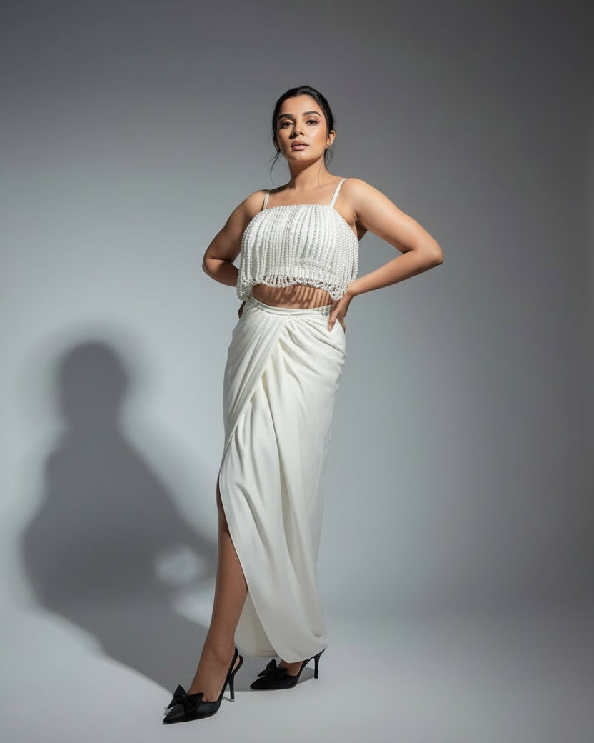 Woman in a white dress standing on a marble platform with a textured wall background