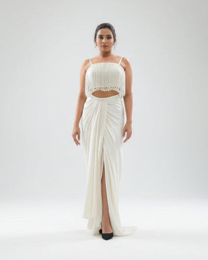 Woman wearing a white dress with a slit on a white background