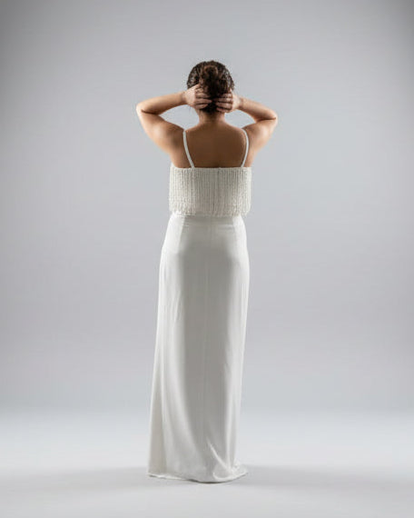 Woman wearing a white dress with a plain background