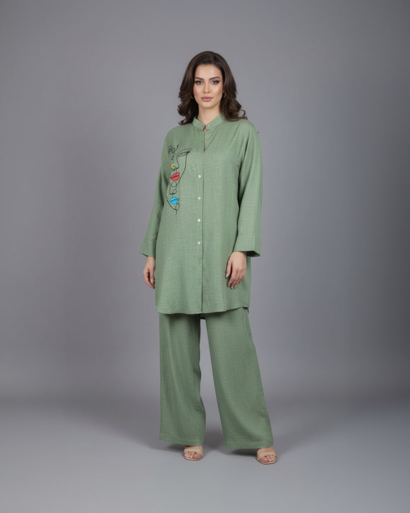 Green outfit with face design on a mannequin against a white wall.