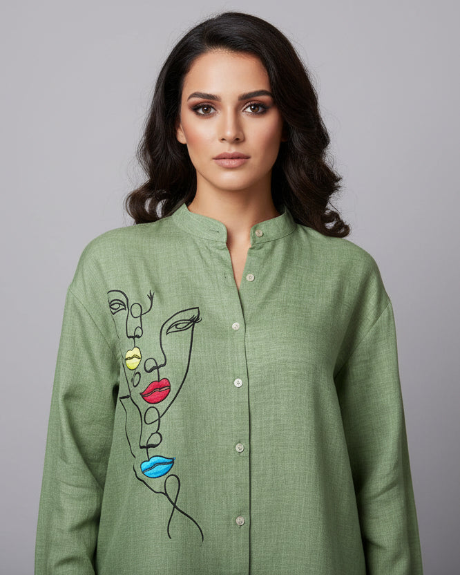 Green shirt with face design on a mannequin against a white background