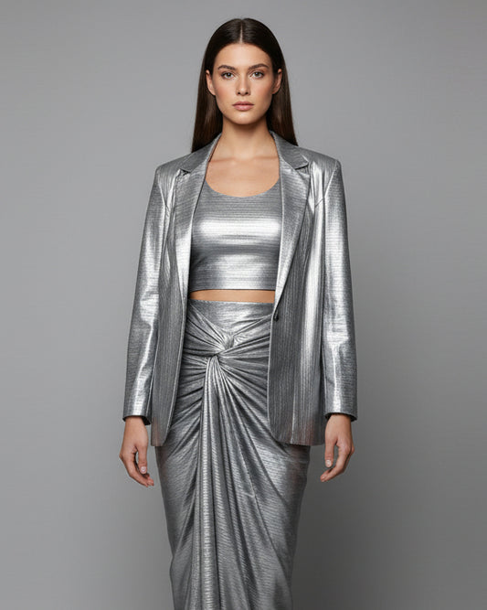Mannequin wearing a silver metallic outfit in a room with a door and tiled floor.