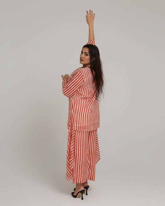 Woman in a red and white striped dress standing in front of large abstract paintings.