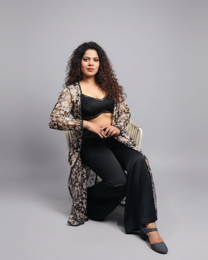 Woman sitting at a table in an indoor setting with a casual pose.