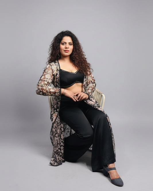 Woman sitting at a table in an indoor setting with a casual pose.
