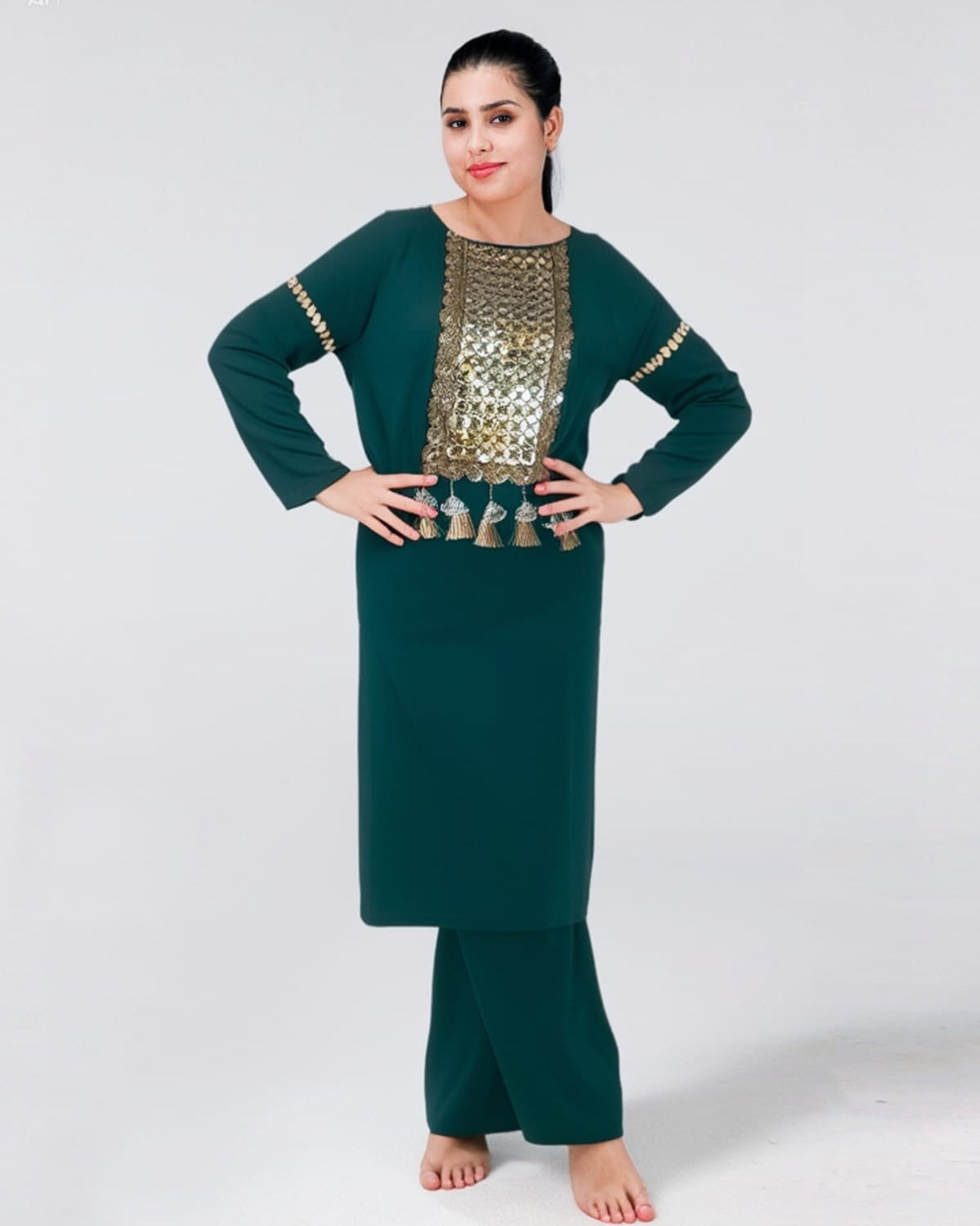 Woman wearing a green traditional outfit with gold embroidery on a white background